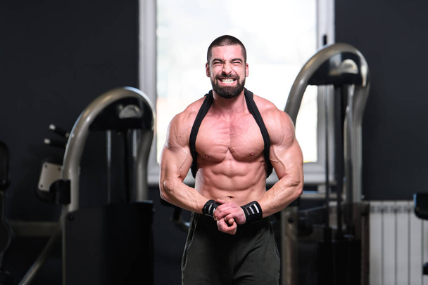 Handsome Young Man Standing Strong In The Gym And Flexing Muscles - Muscular Athletic Bodybuilder Fitness Model Posing After Exercises - Foto, Imagem