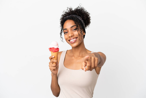 Молода афроамериканська жінка з корнетним морозивом ізольована на білому фоні, що вказує спереду з щасливим виразом. - Фото, зображення