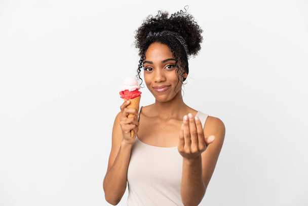 Young african american woman with a cornet ice cream isolated on white background inviting to come with hand. Happy that you came - Fotografie, Obrázek