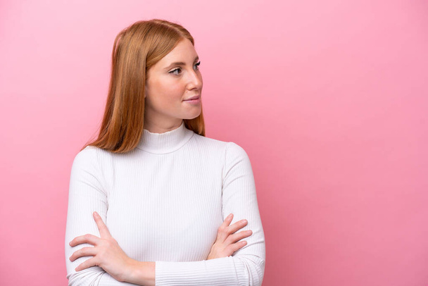Young redhead woman isolated on pink background looking to the side - Photo, Image