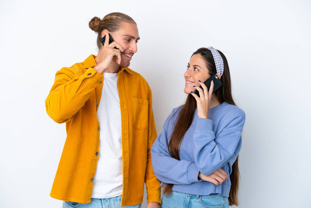 Giovane coppia caucasica isolata su sfondo bianco parlando con il cellulare - Foto, immagini