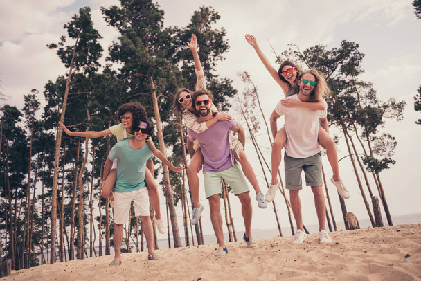 Photo of sweet friendly six young buddies dressed casual outfits walking holding arms piggyback outdoors countryside - Photo, image