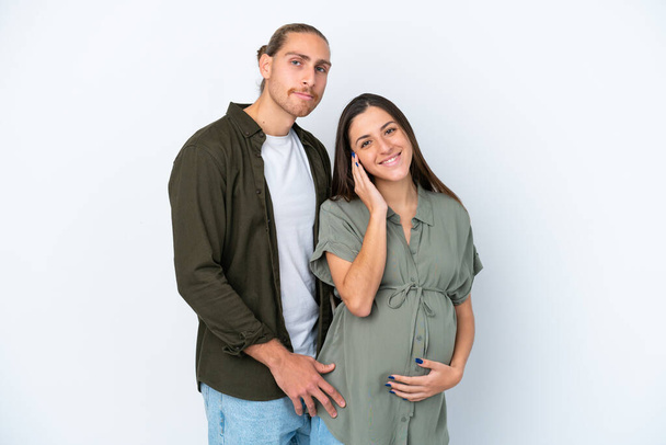 Nuori valkoihoinen pari eristetty valkoisella taustalla raskaana ja onnellinen - Valokuva, kuva