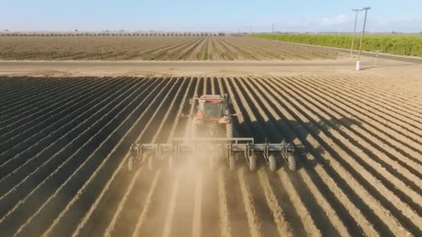 地上に浅い溝を残し、地形を耕すトラクターの空中ビュー - 映像、動画