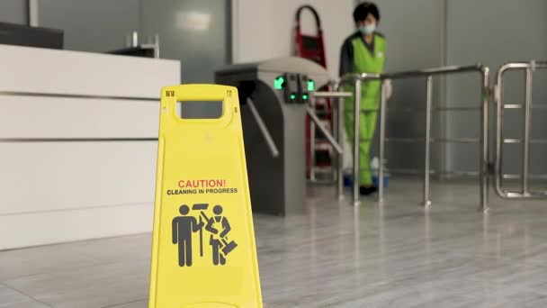 黄色の警告記号には、床が濡れています。注意のサイン表示の警告濡れた床とビジネスの構築の workerw クリーニング ホール床. - 映像、動画