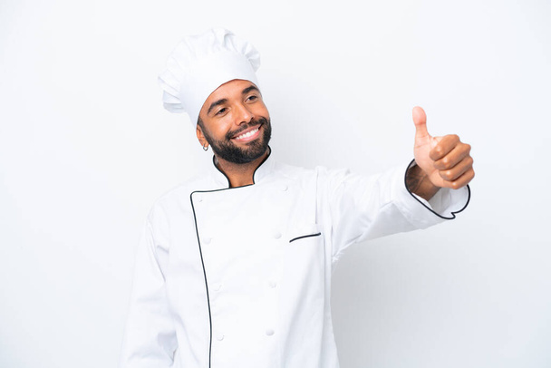 Joven chef brasileño aislado sobre fondo blanco dando un gesto pulgar hacia arriba - Foto, Imagen
