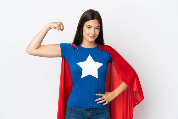 Young Brazilian woman isolated on white background in superhero costume and doing strong gesture - Foto, imagen