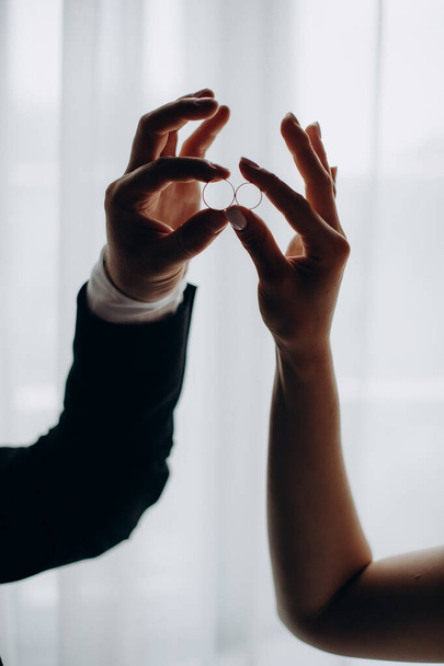 couple holding wedding rings in their hands - Фото, зображення