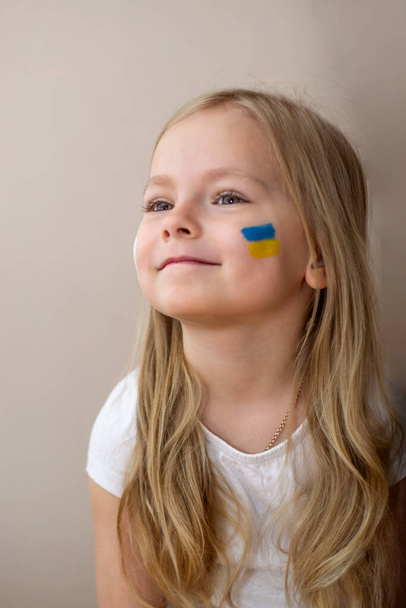 little Ukrainian woman with a picture of the flag of Ukraine and the heart of peace - Fotó, kép