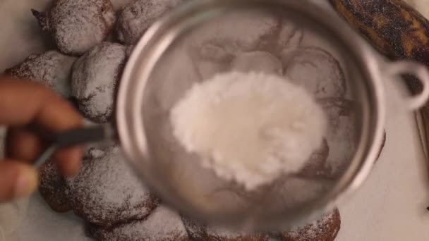 Ripottelua jauhettua sokeria jauhopuhallus pullistuma ylhäältä käyttäen siivilä. Se on versio suosittu Afrikkalainen katu ruoka puff puff valmistettu ylikypsiä jauhoja. - Materiaali, video