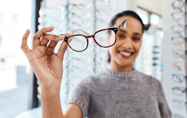 Levez vos lunettes pour une bonne santé oculaire. Prise de vue d'une jeune femme achetant une nouvelle paire de lunettes dans un magasin optométriste. - Photo, image