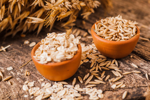 A  Healthy fresh Dry Oat meal .Oat ears of grain on a wooden table, oatmeal. Bounteous harvest.  - Fotografie, Obrázek