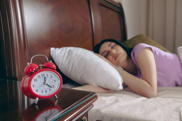 girl sleeping in bed set alarm clock - Φωτογραφία, εικόνα