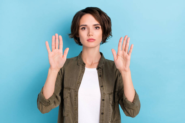 Photo of strict millennial bob hairdo lady show stop wear khaki shirt isolated on blue color background - Foto, afbeelding