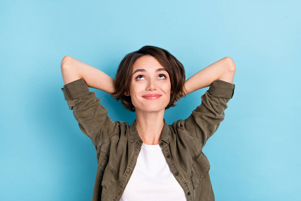 Photo of optimistic young bob hairdo lady hands head look up wear outfit isolated on blue color background - Photo, image