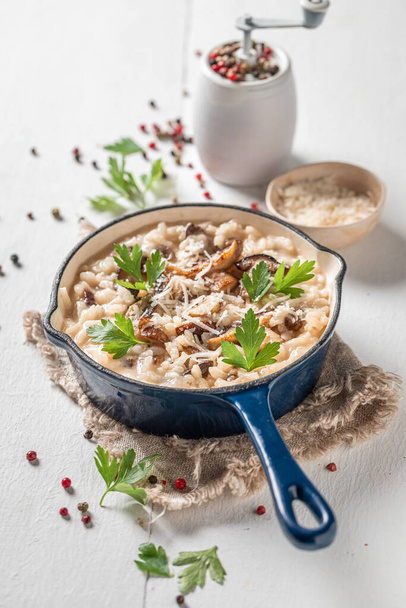 Tasty mushrooms risotto with wild boletus and herbs  on wooden table - Foto, imagen