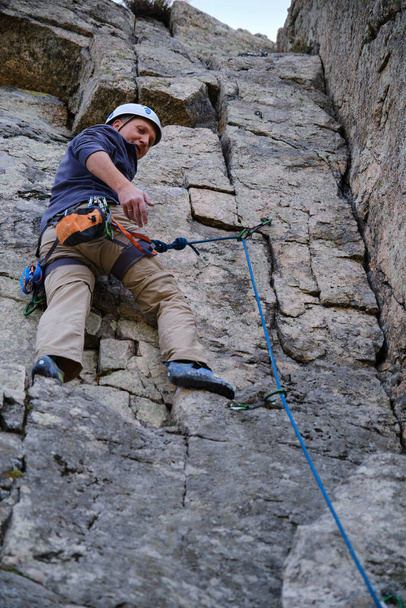 Un escalador hablando desde la pared con su compañero - Foto, imagen