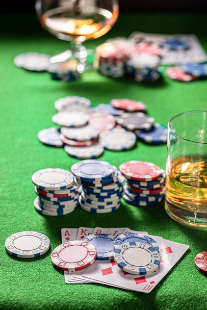 Poker gambling table with whisky, cards and chips. Glass of bourbon with ice on gambling table with cards and chips. - Zdjęcie, obraz
