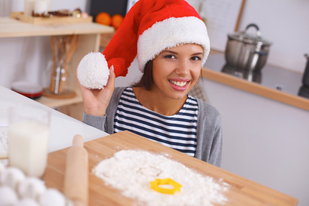 Happy young woman smiling happy having fun with Christmas preparations wearing Santa hat - Fotó, kép