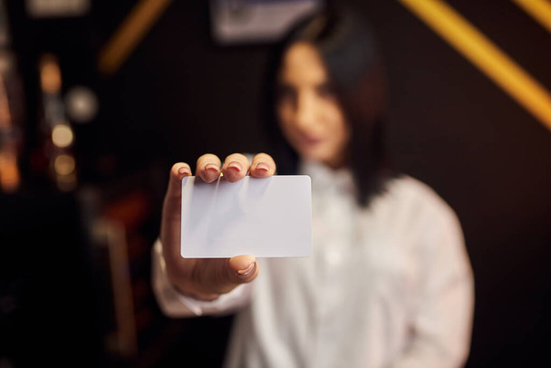 Chica joven positiva caucásica mostrando tarjeta de plástico. Enfoque en Card - Foto, Imagen