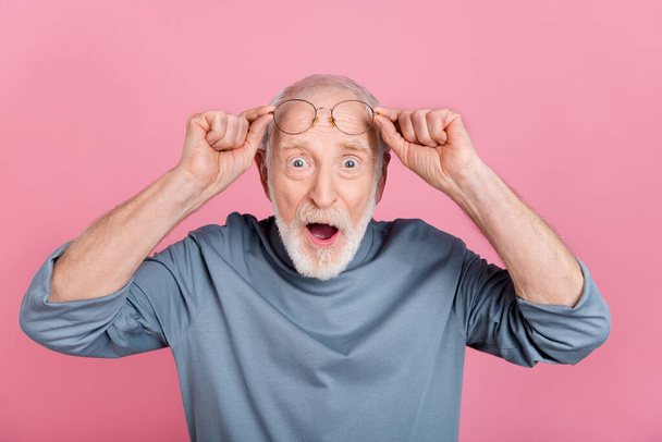 Photo of impressed funky guy pensioner dressed grey pullover arms glasses open mouth isolated pink color background - Foto, afbeelding