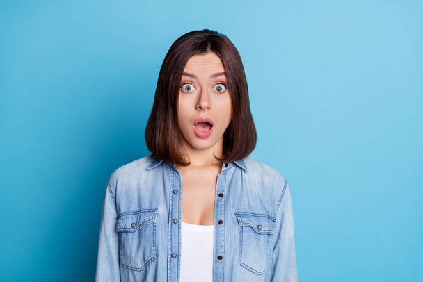 Photo of shiny impressed woman wear jeans shirt big eyes open mouth isolated blue color background - Foto, Imagem