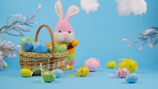 Huevos de Pascua en una cesta. Conejo de Pascua con huevos. Nubes. Feliz tarjeta de Pascua. 4K - Metraje, vídeo