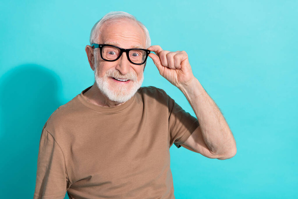 Portrait of attractive cheerful intellectual grey-haired man touching specs isolated over bright blue color background - Photo, image