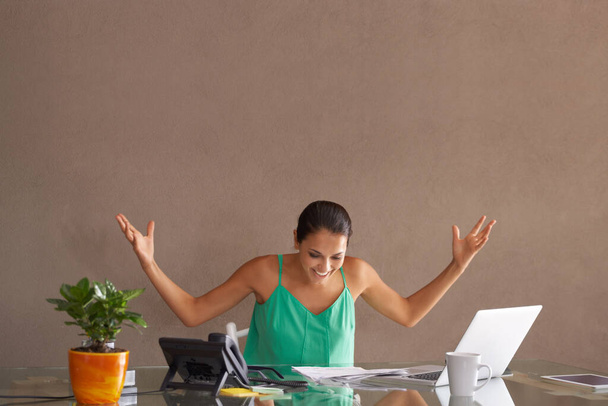 How did I manage to do that. A woman throwing up her hands in surprise as she works from home. - 写真・画像