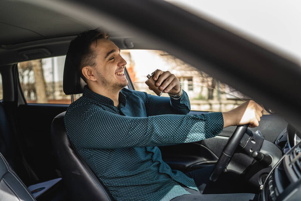 Un uomo adulto maschio caucasico che beve alcol dalla fiaschetta mentre guida un'auto ubriaca - Foto, immagini