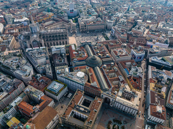 Aerial view of Piazza Duomo in front of the gothic cathedral in the center. Drone view of the gallery and rooftops during the day. Milan. Italy, - Valokuva, kuva