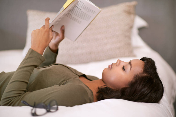 Schlafen Sie weniger, lesen Sie mehr. Aufnahme einer jungen Frau, die im Bett ein Buch liest. - Foto, Bild