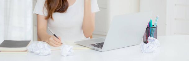 Young asian woman confident working at home with laptop computer and thinking idea for planning, freelance happy girl excited and success using notebook thoughtful and writing, business concept. - Фото, зображення