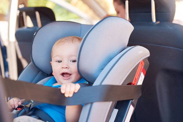 Me voy a una aventura con mamá. Foto recortada de una madre sentada en un coche con su bebé en un asiento de coche. - Foto, Imagen