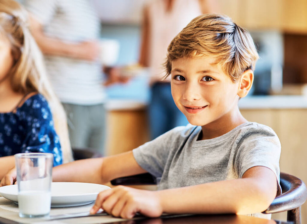 O café da manhã é especialmente importante para crianças em crescimento. Retrato de um menino sentado na mesa de café da manhã em casa. - Foto, Imagem