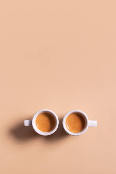 Two ceramic cups of espresso coffee. Top view. Minimalistic monochrome vertical stock photo. - Foto, imagen