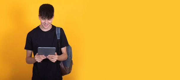 изолированный студент с цифровым планшетом или компьютером и рюкзаком - Фото, изображение