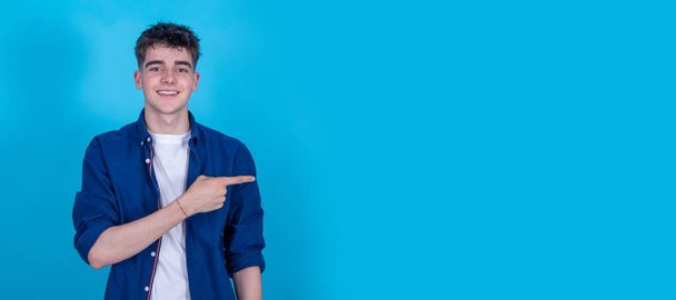 adolescente ragazzo isolato su sfondo blu puntando - Foto, immagini