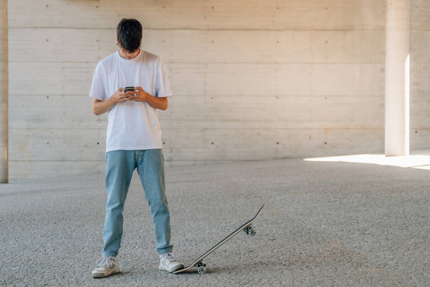 teenager with mobile phone or smartphone in the street - Photo, Image