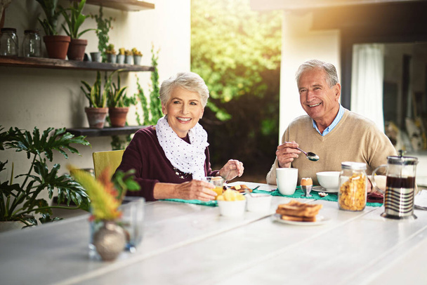 Akik szeretik a reggelit, mindig a legjobb emberek. Egy boldog idős pár portréja, akik együtt reggeliznek otthon.. - Fotó, kép
