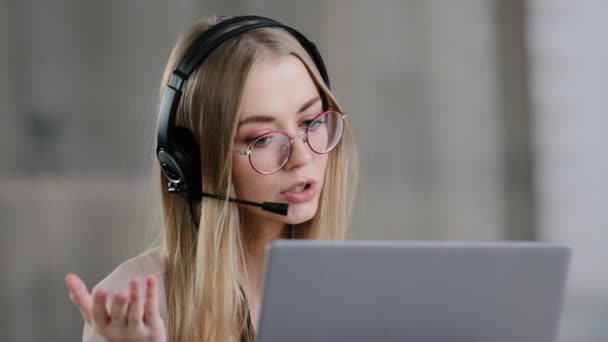 Headshot close up caucasian young girl woman helpline agent manager wearing headset with microphone looking at web camera on laptop studying online consultation insurance in net tutor video class - Footage, Video