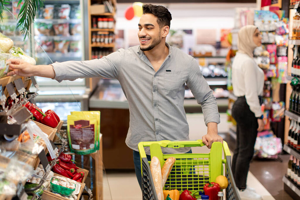 Χαρούμενα Αραβικά Αρσενικά Επιλέγοντας Λαχανικά Ψώνια Στέκεται Στο Σούπερ Μάρκετ - Φωτογραφία, εικόνα