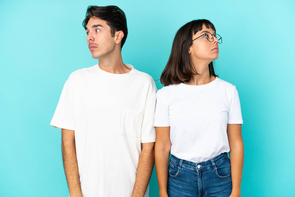 Young mixed race couple isolated on blue background nervous and scared - Foto, afbeelding