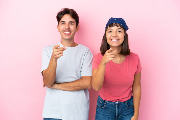 Νεαρό ζευγάρι απομονωμένο σε ροζ φόντο δείχνει το δάχτυλό σας με μια σίγουρη έκφραση - Φωτογραφία, εικόνα