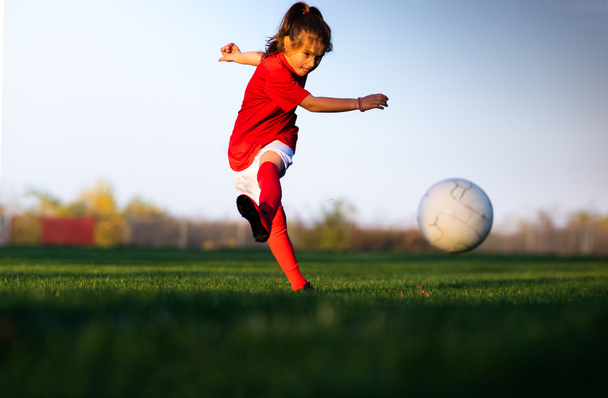 Pieni tyttö treenaa sisätiloissa jalkapallokenttä - Valokuva, kuva
