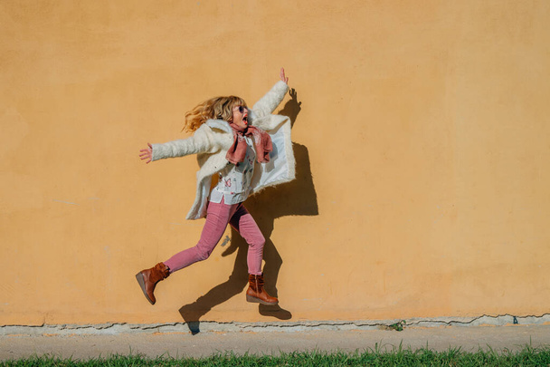 Springende Frau isoliert an der Wand - Foto, Bild