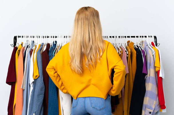 Jonge Uruguayaanse blonde vrouw in een kledingwinkel in achterpositie - Foto, afbeelding