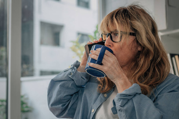 mujer en casa con una taza de café o infusión - Foto, Imagen