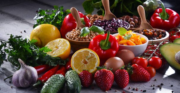 Состав из разнообразных органических продуктов питания на деревянном кухонном столе - Фото, изображение