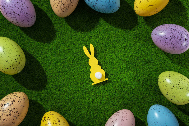 Jarní Velikonoční prázdniny koncept, zajíček a barevné vejce na zeleném travnatém pozadí. - Fotografie, Obrázek